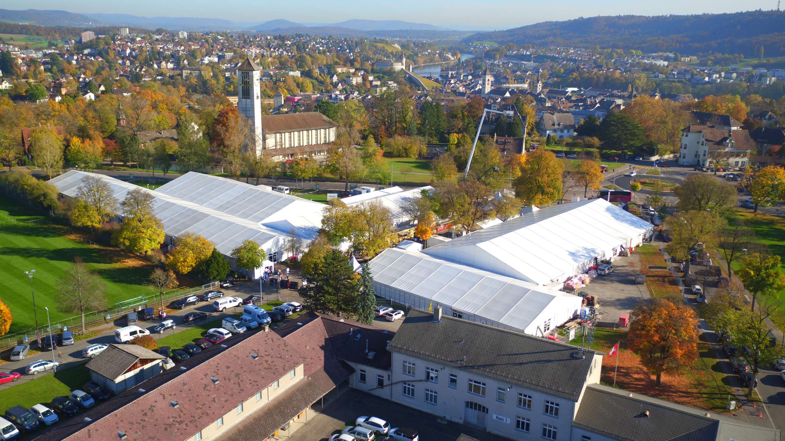 Luftaufnahme Schaffhauser Herbstmesse. Das Messeareal mit mehreren weissen Zelten. Die Bäume rundherum sind in herbstlichen Farben.