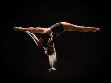 Eine Akrobatin welche sich auf einem Arm balanciert.