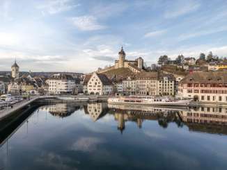 Blick vom klaren Rhein auf die winterliche Altstadt mit Schiff und Munot.