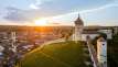 Blick auf die Rundfestung Munot mit Reben. Dahinter sieht man die Schaffhauser Altstadt. Hinter dem Hügel geht die Sonne unter.