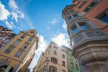 Häuser auf dem Fronwagplatz Schaffhausen in gelb, ocker und grün. Sicht auf den Fronwagturm mit Fronwaguhr und Erker