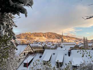 Blick auf die Steiner Altstadt und die Burg Hohenklingen. Die Hausdächer sind mit Schnee bedeckt und die Abendsonne wirft ein goldiges Licht.