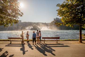Eine Gruppe mit Guide stehen vor dem Rheinfall, dem grössten Wasserfall Europas.
