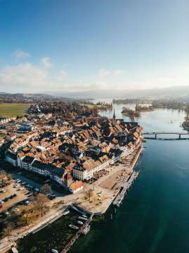 Blick von oben auf die Steiner Altstadt und den klaren, ruhigen Rhein.