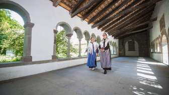 Zwei Frau verkleidet als Hugenotten laufen durch den Kreuzgang Schaffhausen. Eine trägt eine blaue und die andere eine violette Schürze.