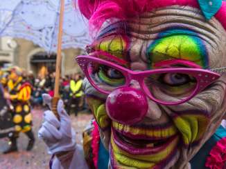 Eine riesige Clown-Fasnachtsmaske mit pinker Brille.