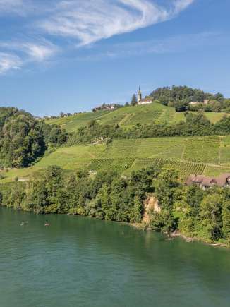 SUP Buchberg-Rüdlingen Zwei Stand up Paddler fahren auf dem Rhein in Buchberg-Rüdlingen. Oberhalb der Reben am Ufer ist die Kirche.