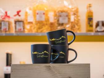 Auf schwarzen Tassen wurde in gelb die Skyline von Schaffhausen graviert. Darunter steht in gelb "Schaffhausen". Innen ist die Tasse gelb.