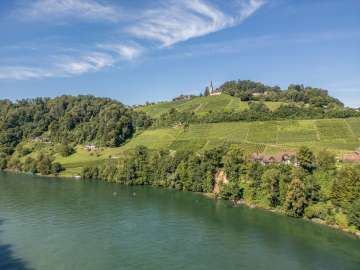 SUP Buchberg-Rüdlingen Zwei Stand up Paddler fahren auf dem Rhein in Buchberg-Rüdlingen. Oberhalb der Reben am Ufer ist die Kirche.