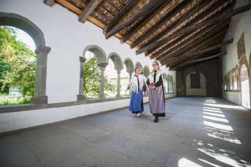 Zwei Frau verkleidet als Hugenotten laufen durch den Kreuzgang Schaffhausen. Eine trägt eine blaue und die andere eine violette Schürze.