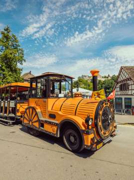 Ein oranger touristen Zug steht im Rheinfallbecken.
