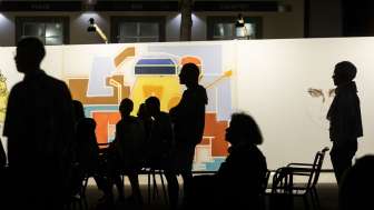 Personen stehen in einer Kunstaustellung.