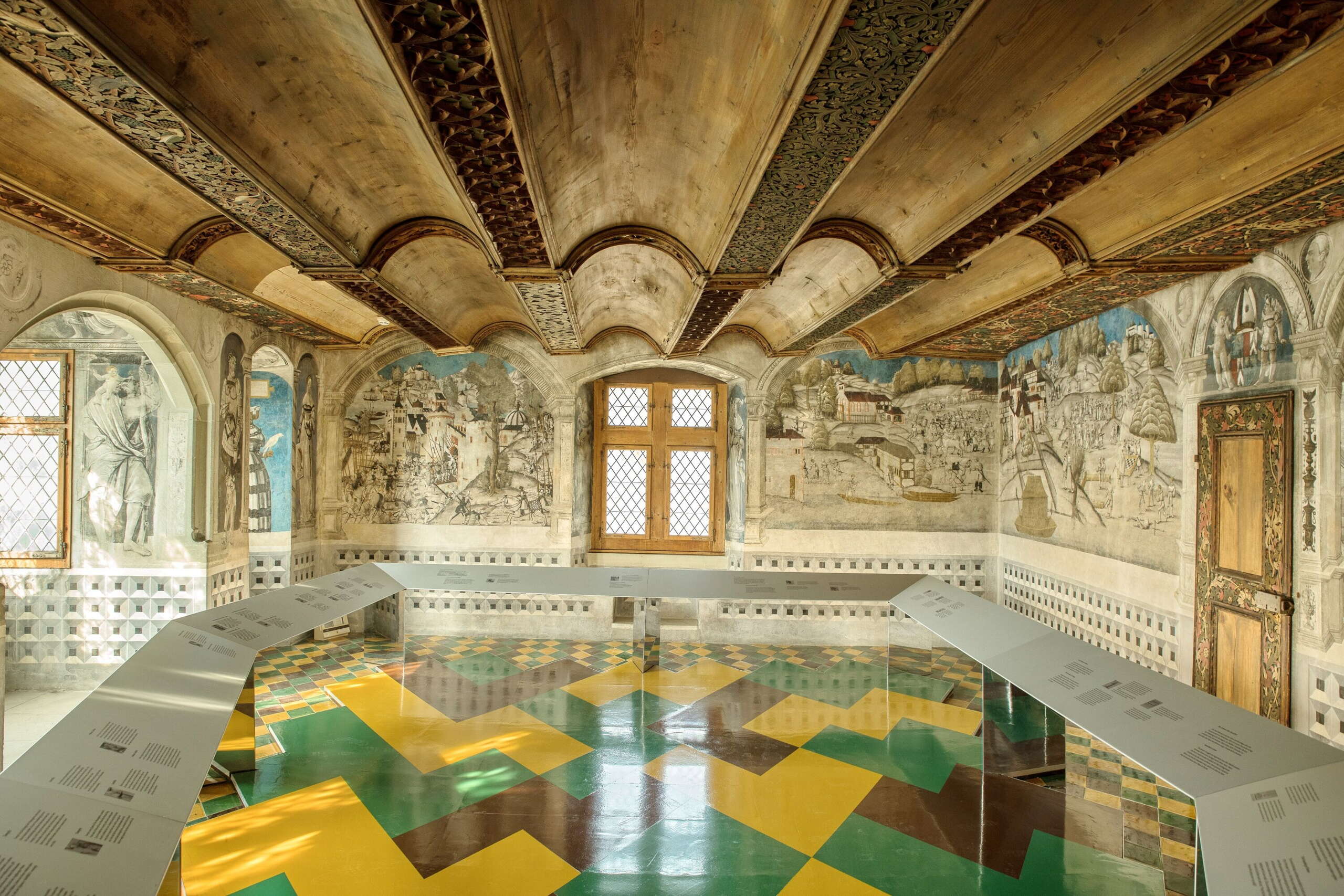 Zimmer im Kloster St. Georgen in Stein am Rhein. Wände sind mit kunstvollen Zeichnungen dekoriert, der Boden ist grün, gelb und braun geplättelt