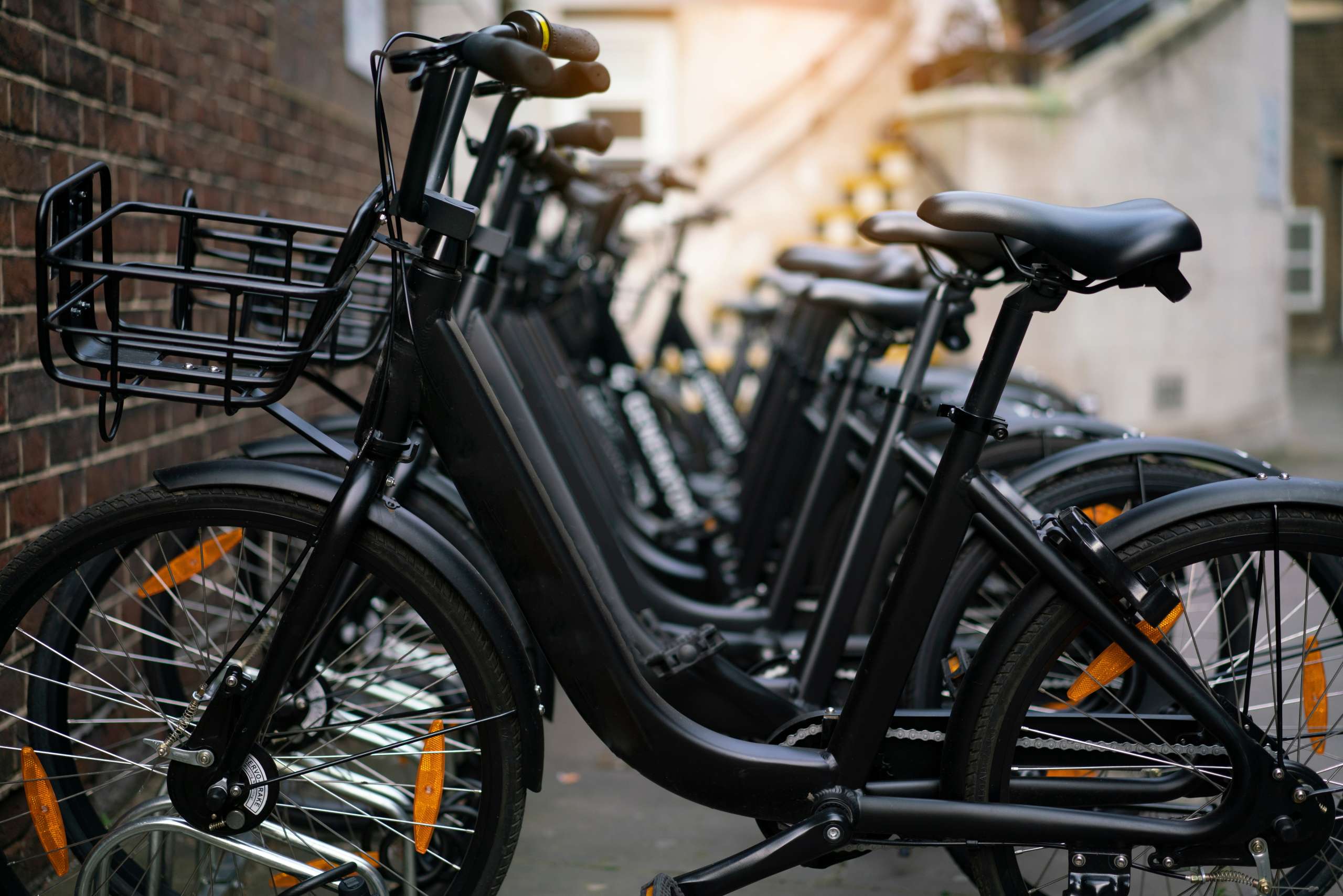 Mehrere schwarze E-Bikes stehen ordentlich nebeneinander in einer Reihe.