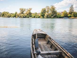 Weidling Schaffhausen Ein traditionelles Schaffhauser Holzboot ist am Ufer angelegt. Man blickt auf den Rhein und das grüne Rheinufer.