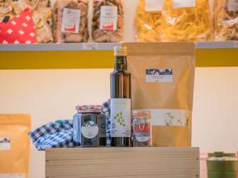Verschiedene Traubenkern-Produkte wie ein Wärmekissen, Öl, Brotbackmischung oder Gelee stehen auf einer Holzkiste.