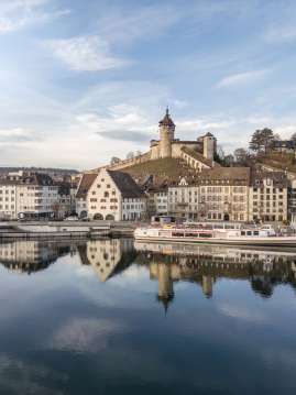 Blick vom klaren Rhein auf die winterliche Altstadt mit Schiff und Munot.