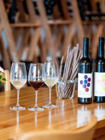 Leibacher Wein Stein am Rhein Auf einem Holztisch stehen Grisini, eine Falsche Rot- und eine Falsche Weisswein sowie zwei Weisswein- und ein Rotweinglas.