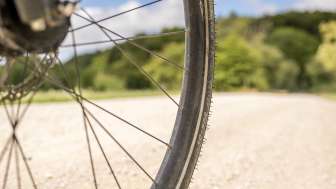 Velorad Teil eines Velorades, das auf einem Naturweg fährt. Im Hintergrund sieht man den Waldrand.