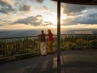 Eine Mutter steht mit ihrer Tochter auf der Aussichtsplattform des Hagenturms. Die Sonne geht bald unter.