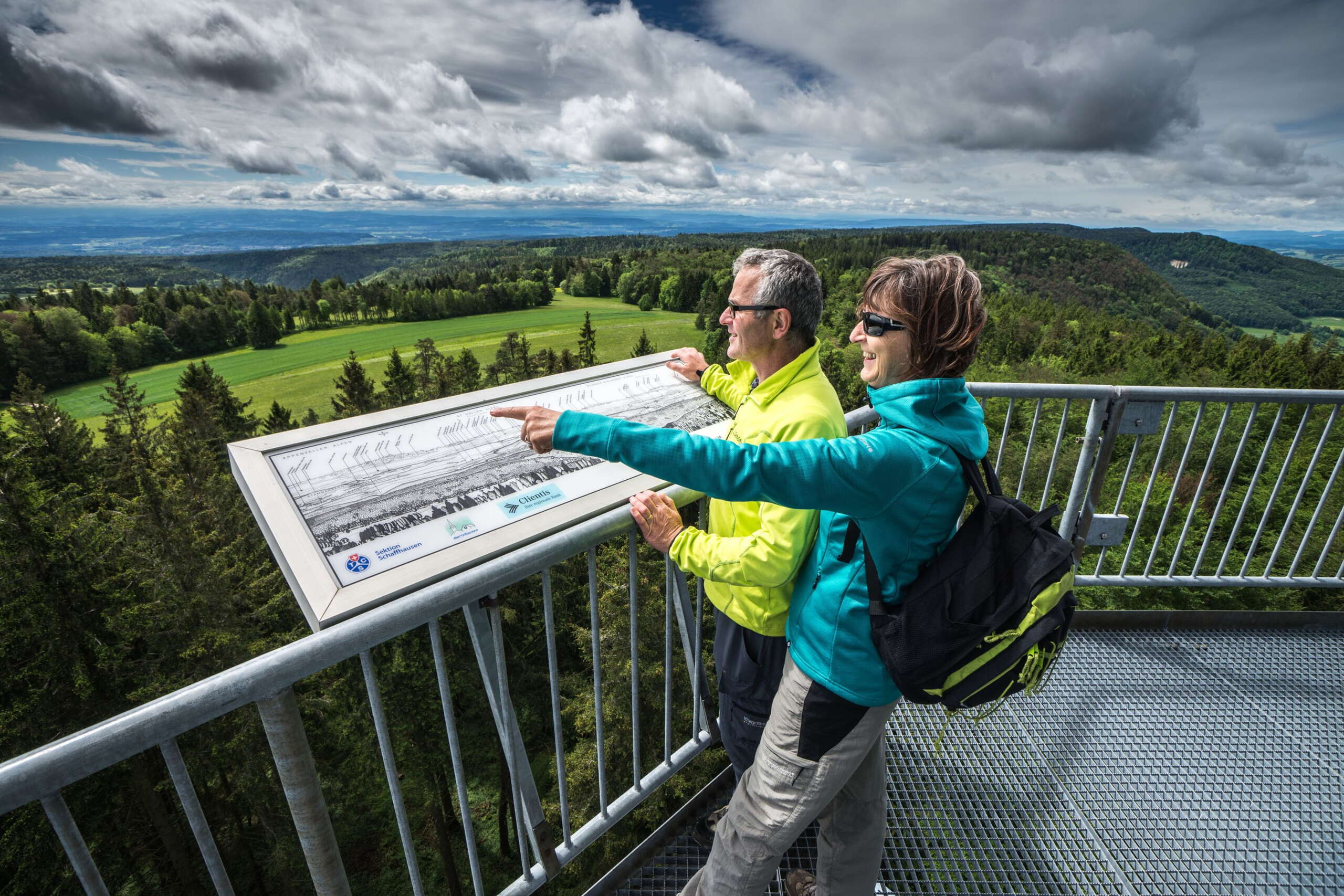 Zwei Wanderer auf dem Hagenturm betrachten die Aussicht.