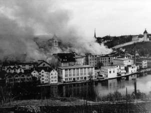 Der schwarze 1. April Ein altes schwarz weiss Bild von einer Stadt. Dunkle Wolken steigen über der Stadt auf.
