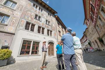 Stadtführung Stein am Rhein Eine Gruppe steht vor einem Haus mit Fassadenmalereien. Ein Guide erzählt mehr darüber.
