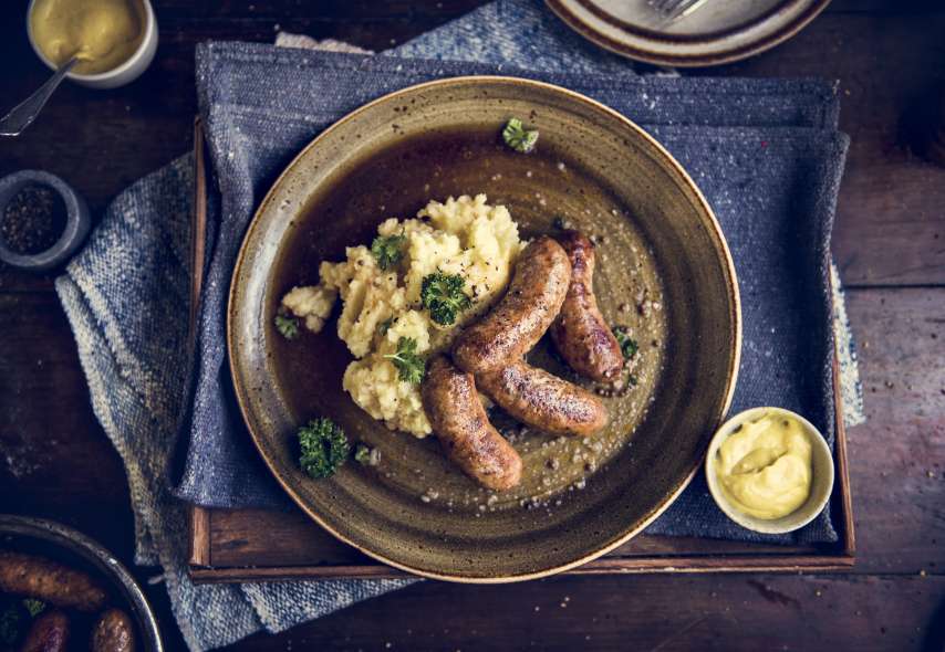 Schön angerichteter Teller mit Kartoffelstock und Würsten