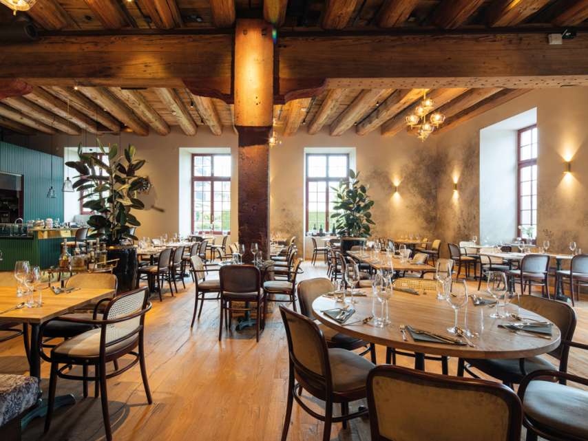 Restaurant Güterhof in Schaffhausen mit gedeckten Holztischen. Grosser offener Raum mit Säulen.