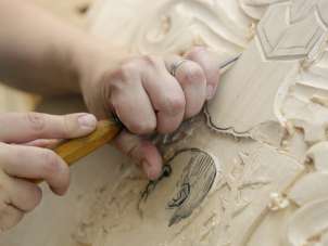 Erlebnis Holzbildhauerei Wilchingen Mit einem Werkzeug wird aus einer Holzplatte ein Bild gemacht.