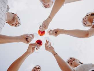 Räbhüüslifest Hallau Fünf Freunde halten Weinglässer in die Luft und stossen an.