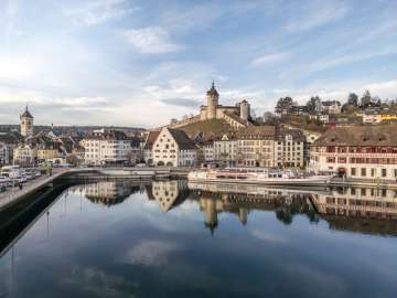 Blick vom klaren Rhein auf die winterliche Altstadt mit Schiff und Munot.