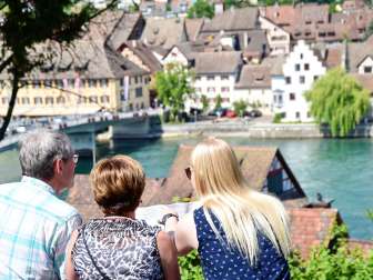 Stadtführung Stein am Rhein Drei Personen schauen genau auf einen Plan. Im Hintergrund sieht man den Rhein und die Steiner Altstadt.
