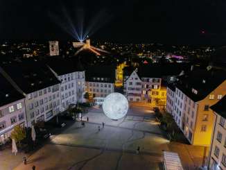 Blick von Oben in der Nacht auch den beleuchteten Munot. Lichtstrahlen leuchten in den Nachthimmel.