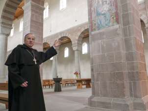 Abt Michael und sein Kloster Ein Mann in einem Mönchskostüm steht in einer Kirche.