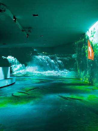 Rhyality Rhienfall Programm Ein Raum mit diversen Projektoren. Die Wänden werden mit Wasser Bildern bespielt.