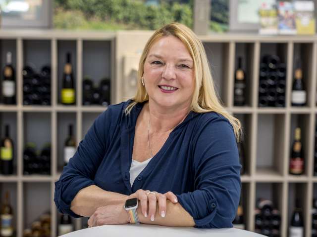 Portrait Sabine Engl. Sie hat blonde Haare trägt ein weisses Shirt und ein dunkelblaues Jäckli.