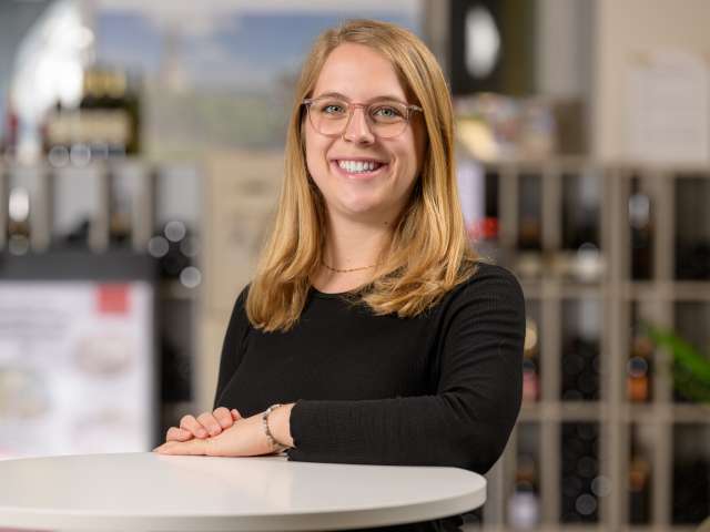 Portrait Pia Sulser. Sie hat blonde Haare, trägt eine Brille und ein schwarzes Langarmshirt.
