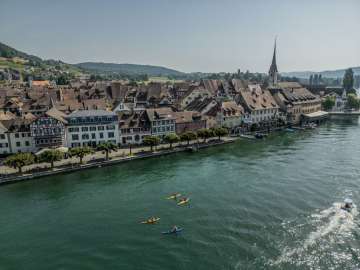 Kanu Stein am Rhein Drei gelbe und ein blaues Kanu fahren auf dem Rhein vor der Altstadt Stein am Rhein.