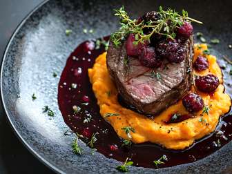 Ein Stück Fleisch ist auf einem Teller angerichtet.