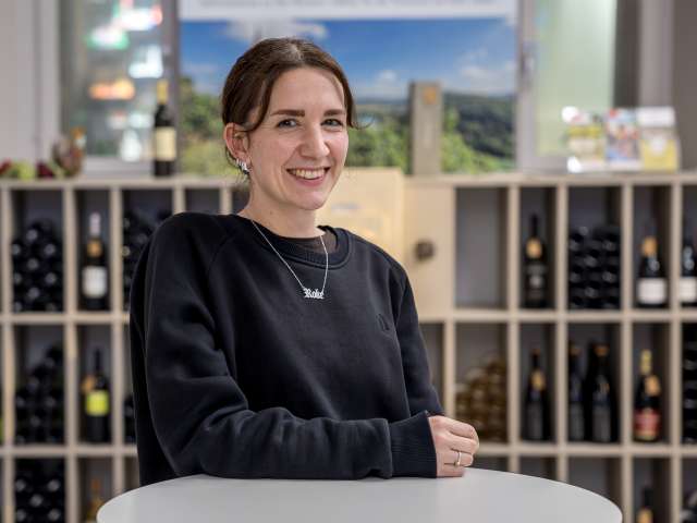 Portrait Helen Eichenberger. Sie hat zusammengebunden schwarze Haare und trägt einen schwarzen Pullover und eine Silbrige Kette.